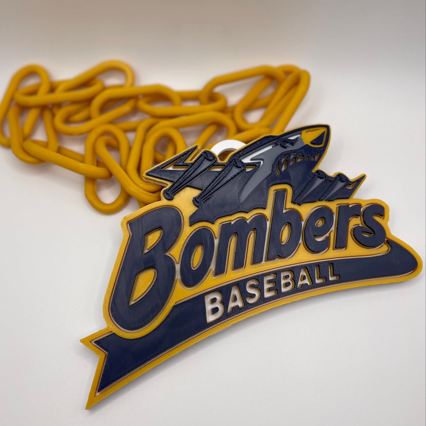 Baseball team logo with 'Bombers' and 'Baseball' text on a yellow chain against a white background