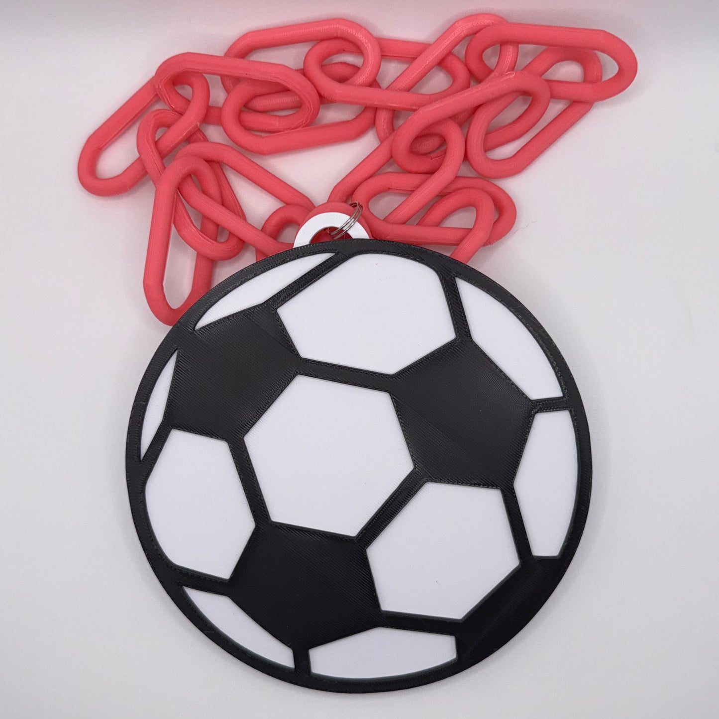 Black and white soccer ball decal on a laptop with red paper clips.